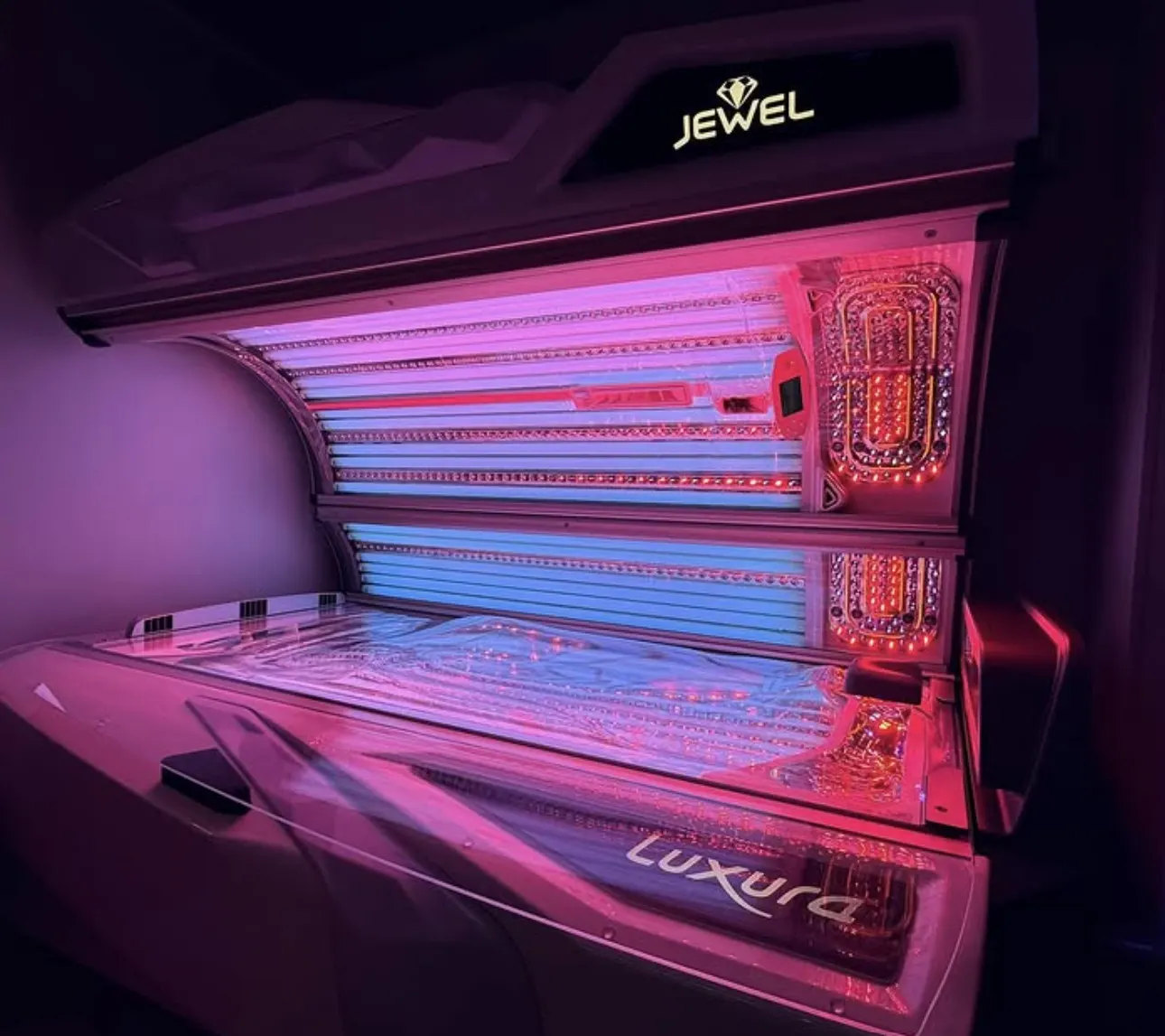 A Luxura Jewel in a salon, canopy open, the tubes lit blue and pink