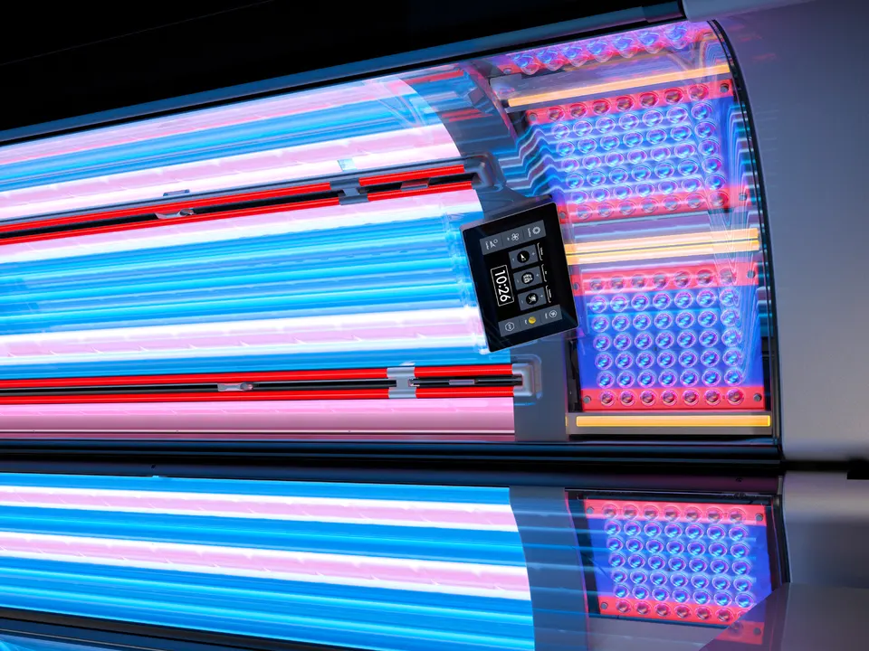 SunSphere facial panels at the head of an open K-Series canopy: rows of LED lenses, yellow UV-B lamps between them, and the inside touch display