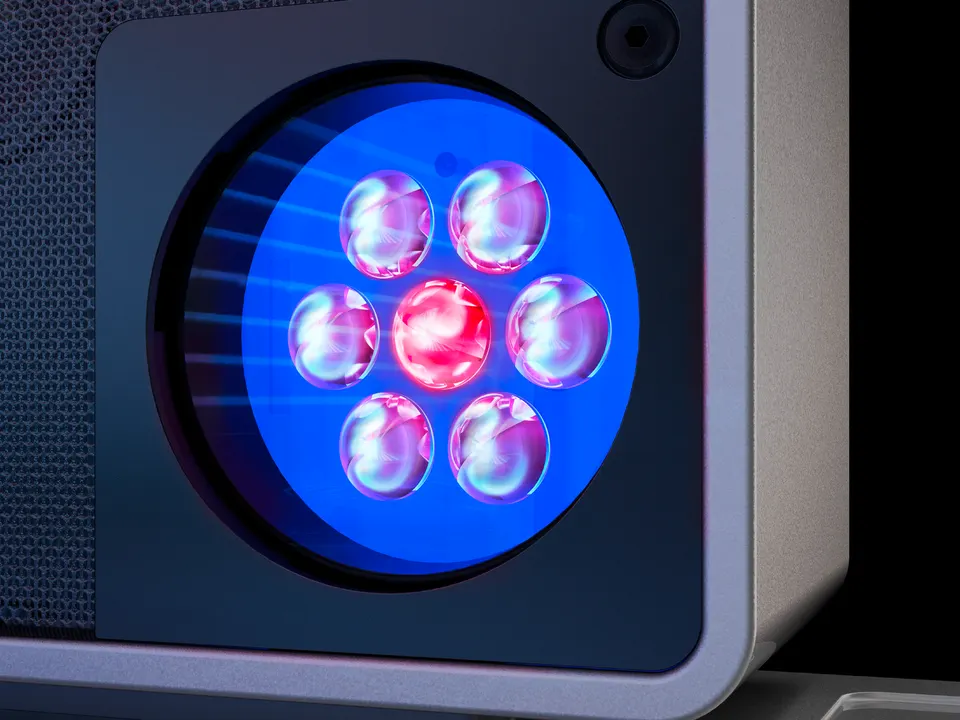 A SunSphere shoulder tanner up close: LEDs glowing blue and red behind a round lens